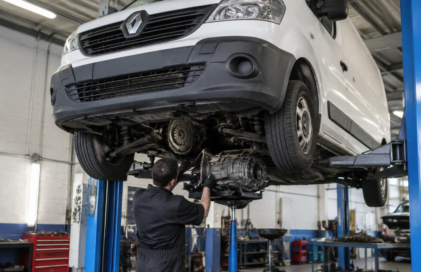 Mechanik demontujący skrzynię biegów Renault Trafic na podnośniku