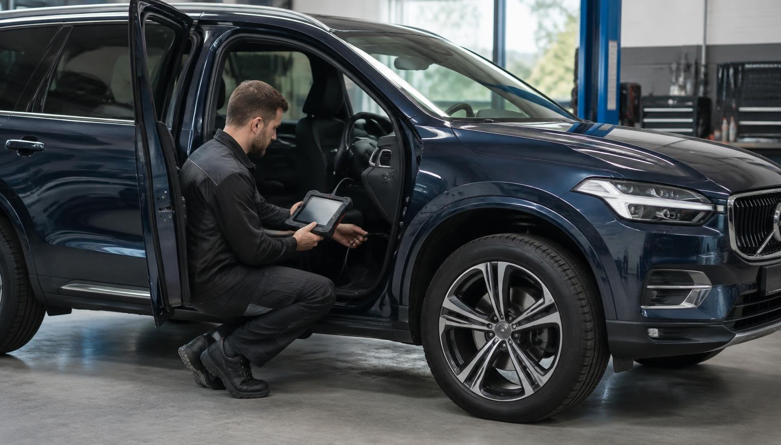 Mechanik podłączający tester diagnostyczny do Volvo XC60